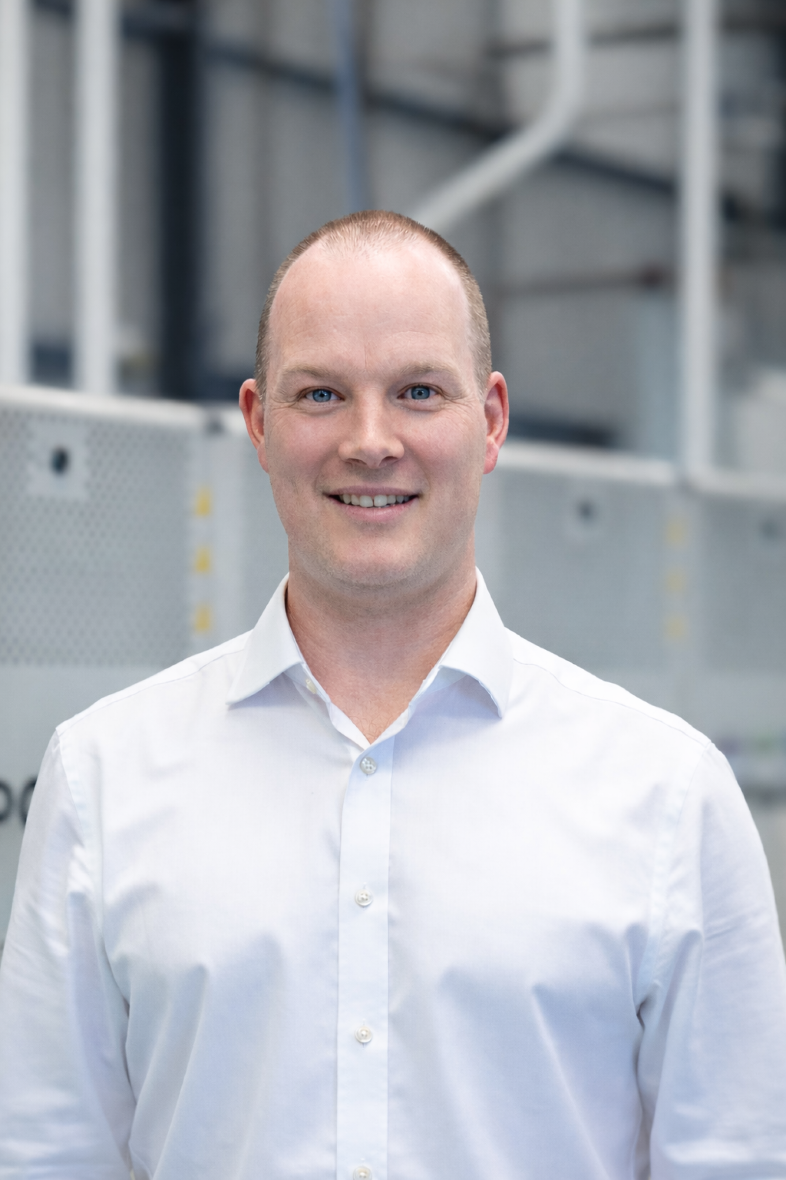 Photo of Ronan Fenton, a white man in a white shirt with cropped reddish-brown hair
