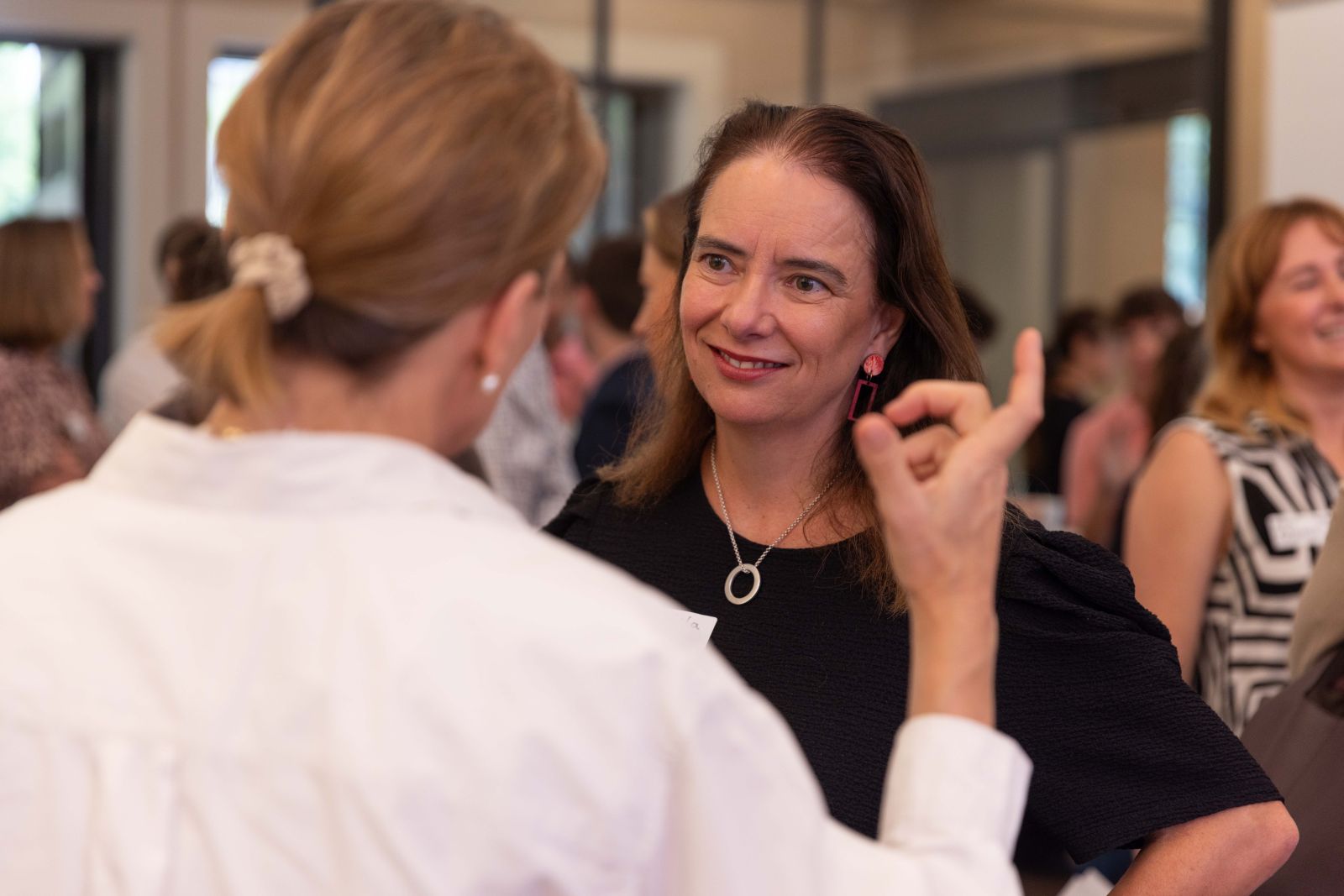 Two white women with dark hair in conversation at a Sefa event
