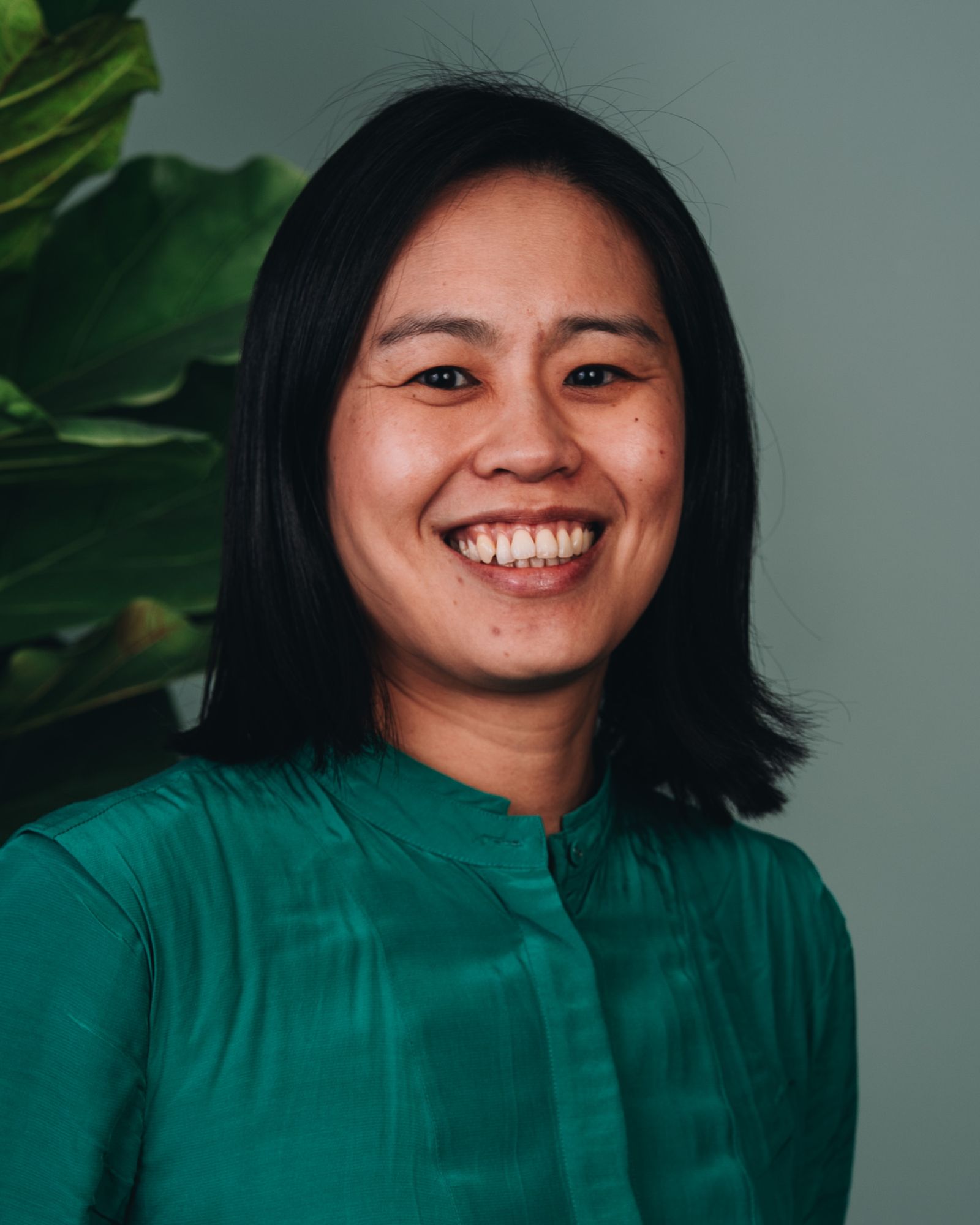 Cindy wears a green shirt and a big smile